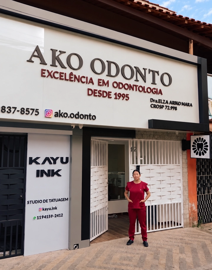 Fachada real da AKO ODONTO, com a Dra. Elza na entrada da clínica